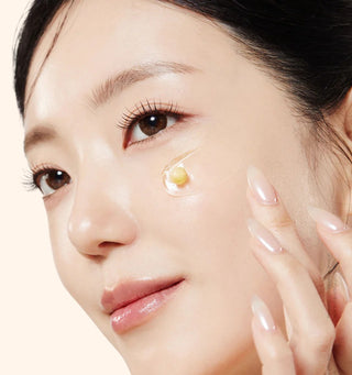 Donna che applica un trattamento contorno occhi con capsula attiva sulla pelle luminosa e levigata, skincare coreana rigenerante