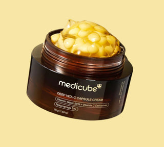 Vaso aperto di Medicube Deep Vita C Capsule Cream con capsule gialle visibili, crema viso illuminante con vitamina C e niacinamide